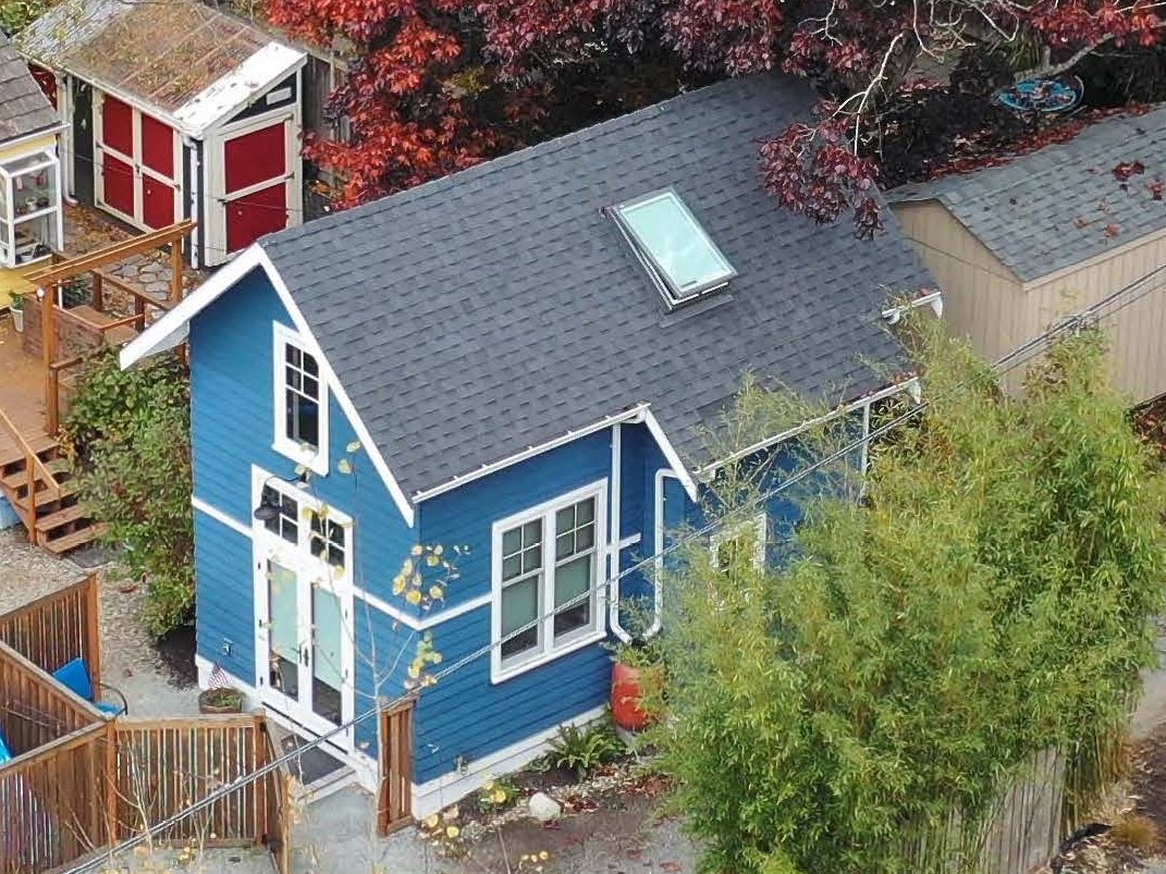 Aerial view of blue cottage ADU with skylight