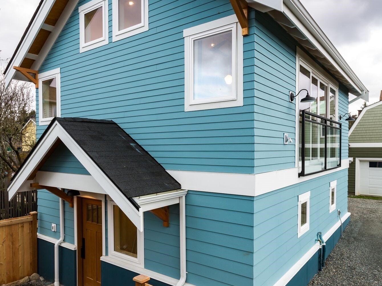 Two-story blue cottage ADU with traditional craftsman styling